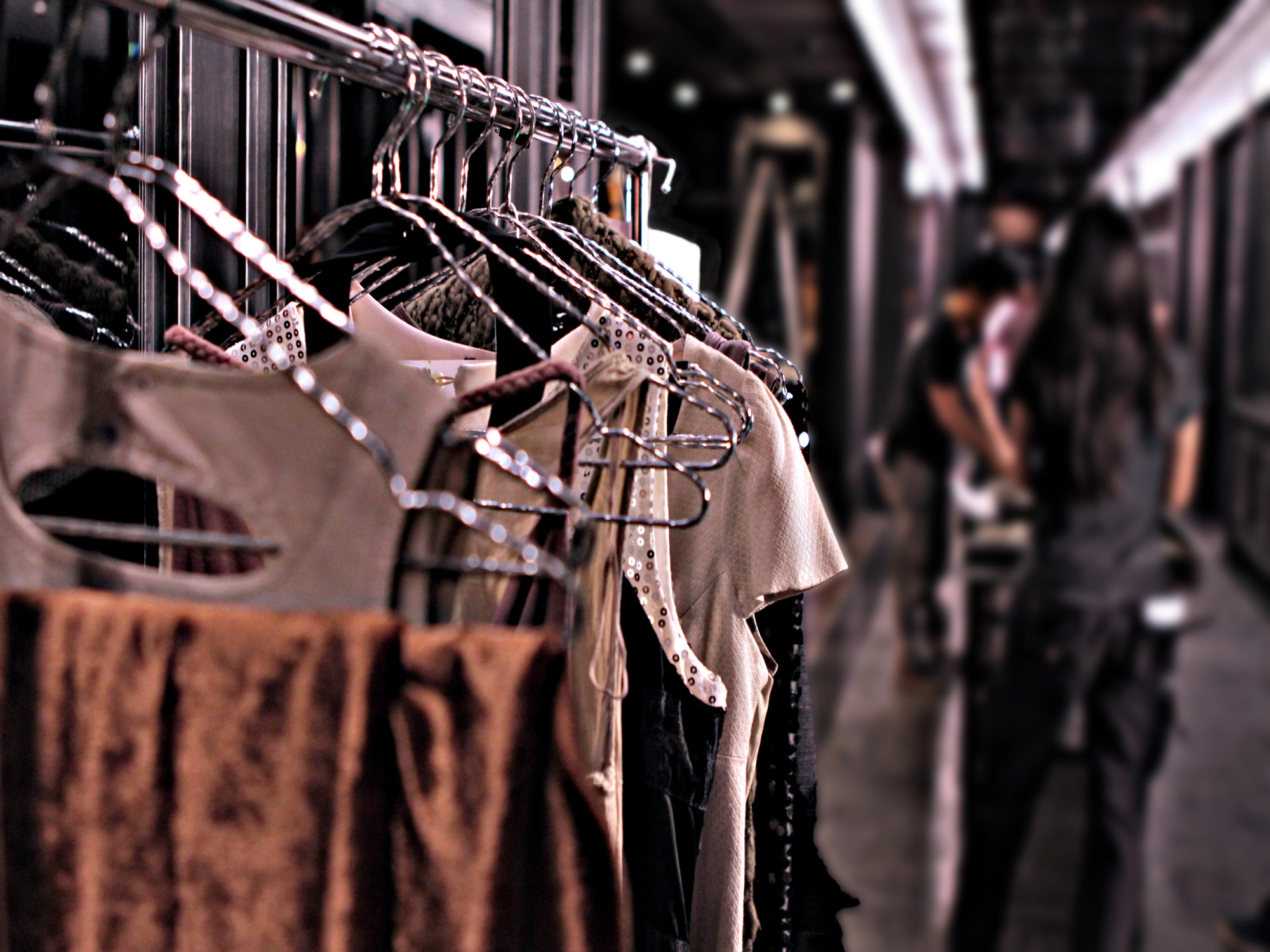 Clothing rack with luxury clothes in dressing area of fashion show.