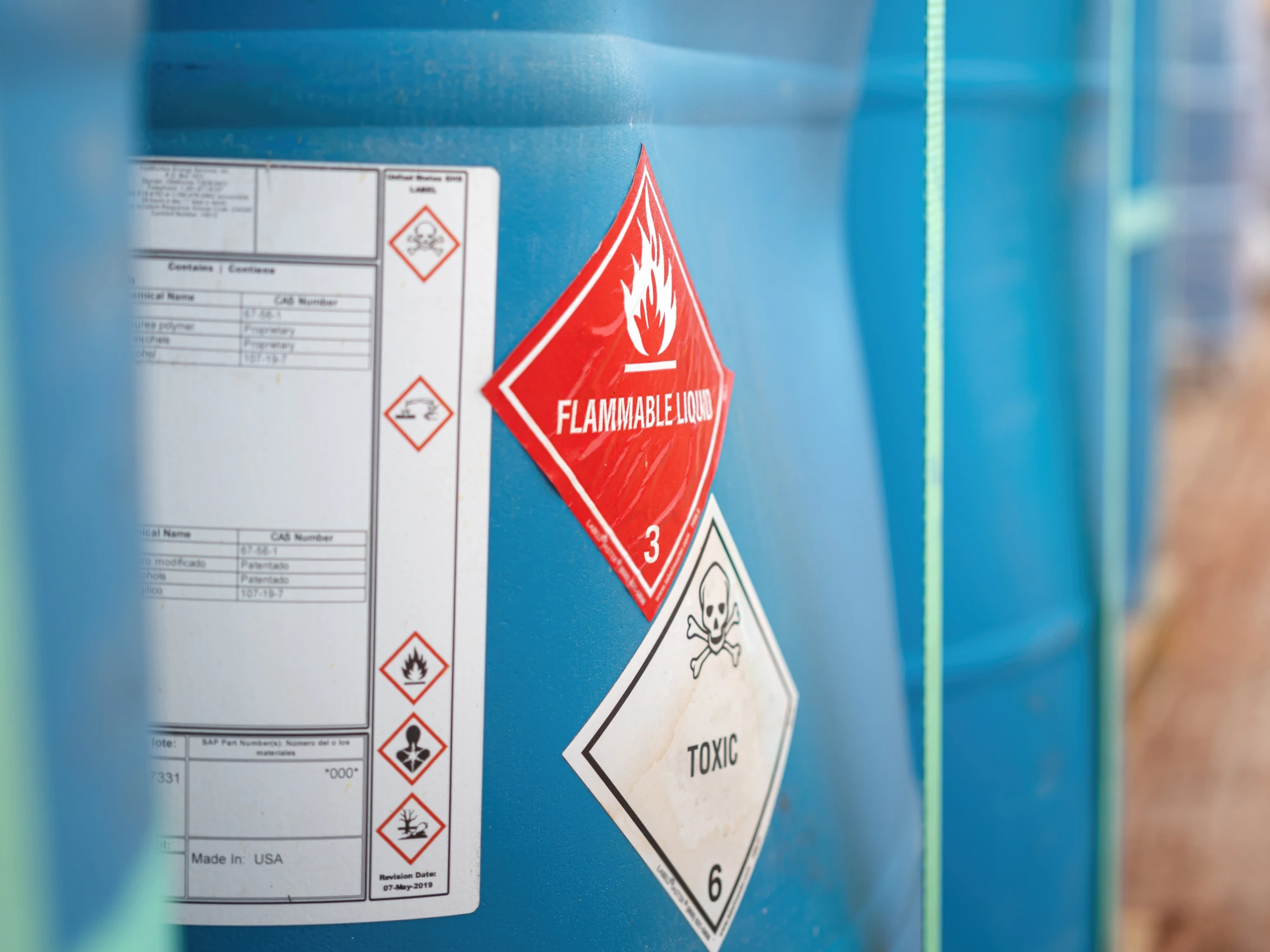 A blue container featuring flammable and toxic labels on the side.